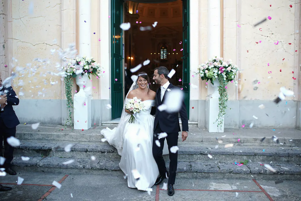 Bride and groom leaving the church under a shower of petals.