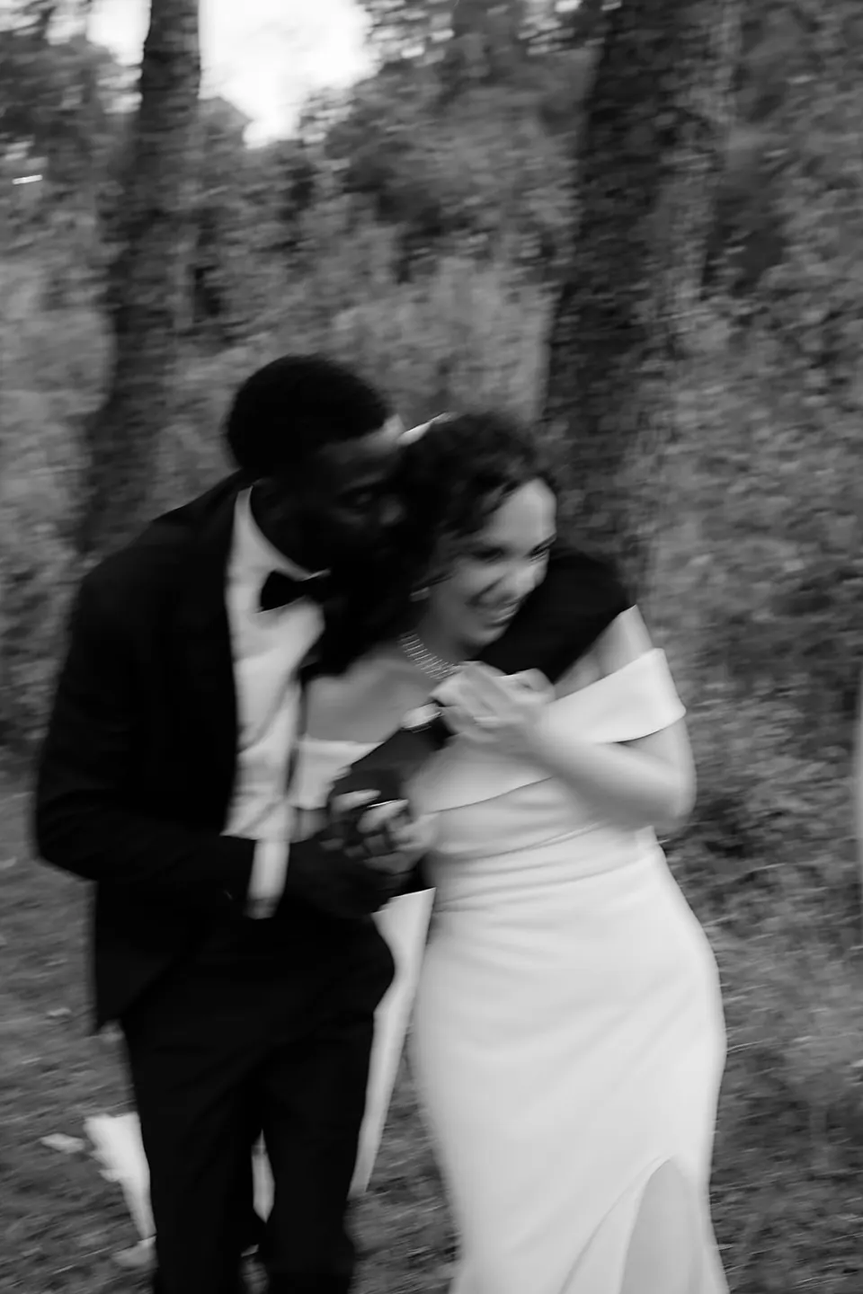 Abrazo en blanco y negro en el bosque de la villa, el novio estrechando a la novia.
