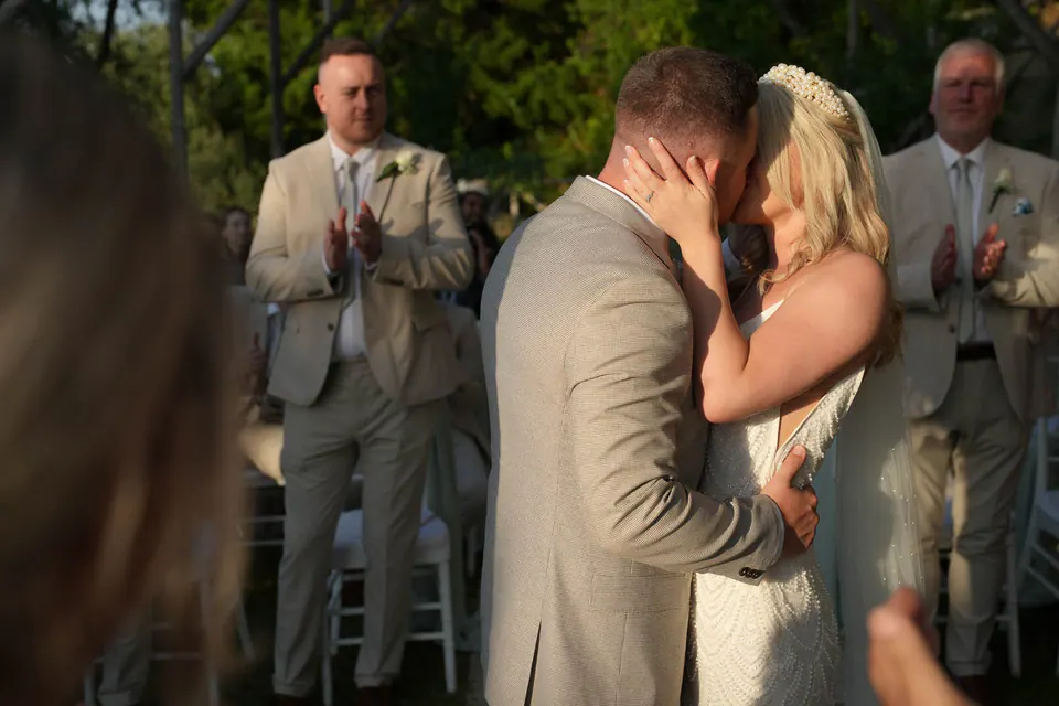 Il primo bacio degli sposi alla cerimonia tra gli invitati
