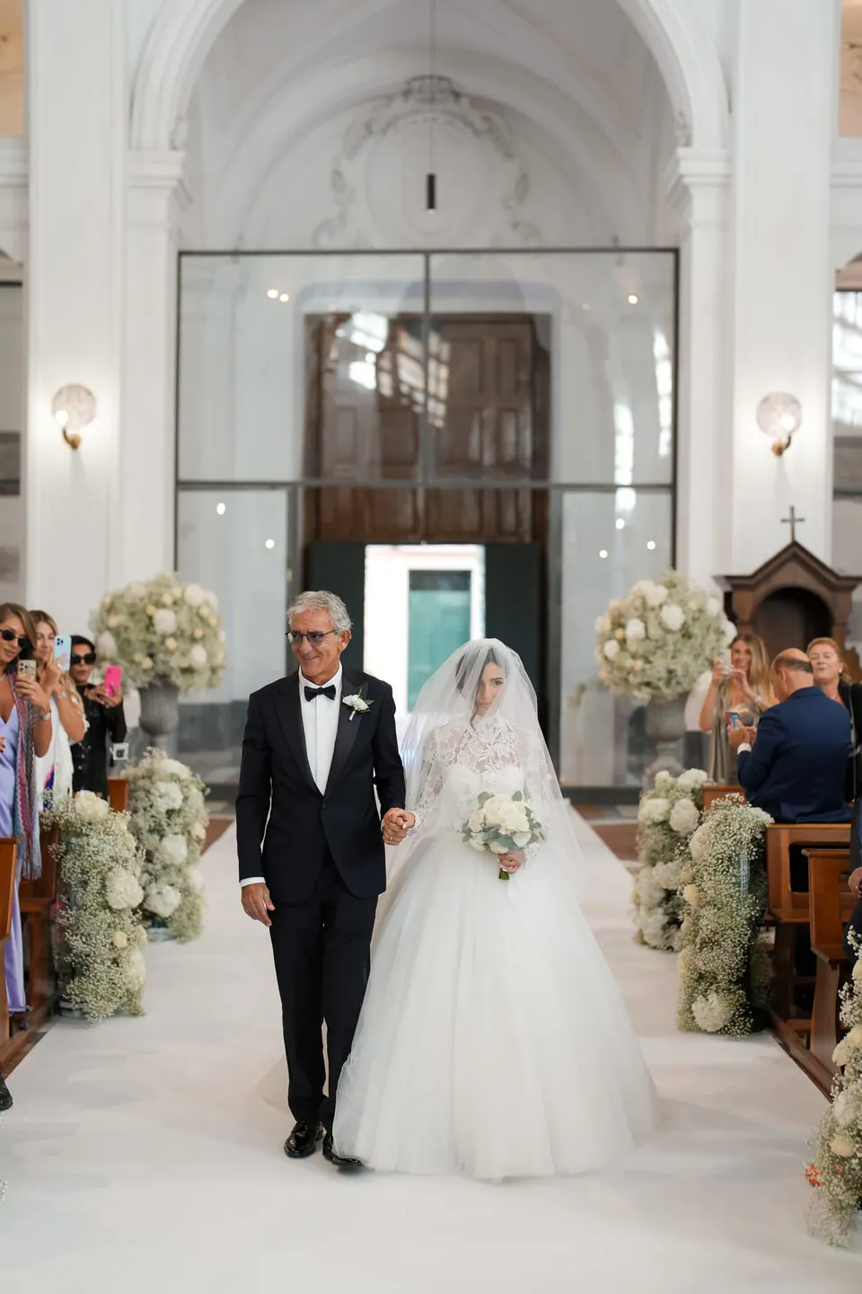 Bride walking down the church aisle with her father