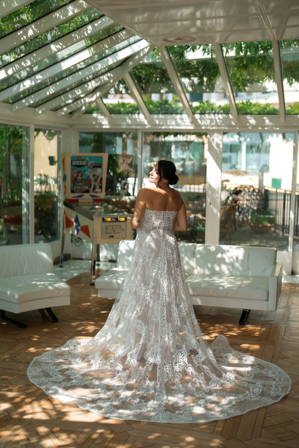 Bride standing in the veranda in her lace gown, the train spread in a circle around her.