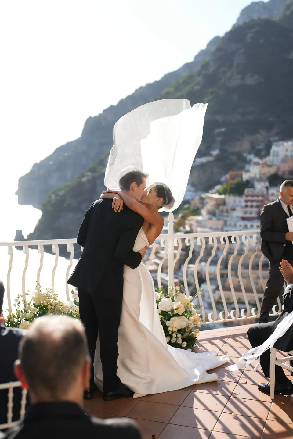 Groom dipping the bride for a kiss as her veil flies up.