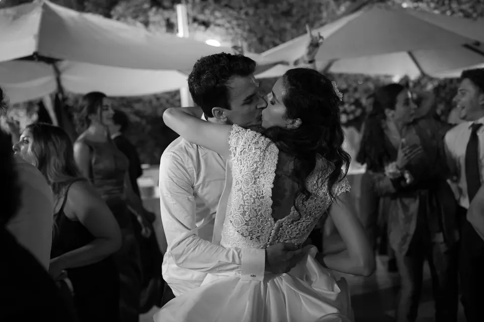 Black and white photo of bride and groom hugging among the guests