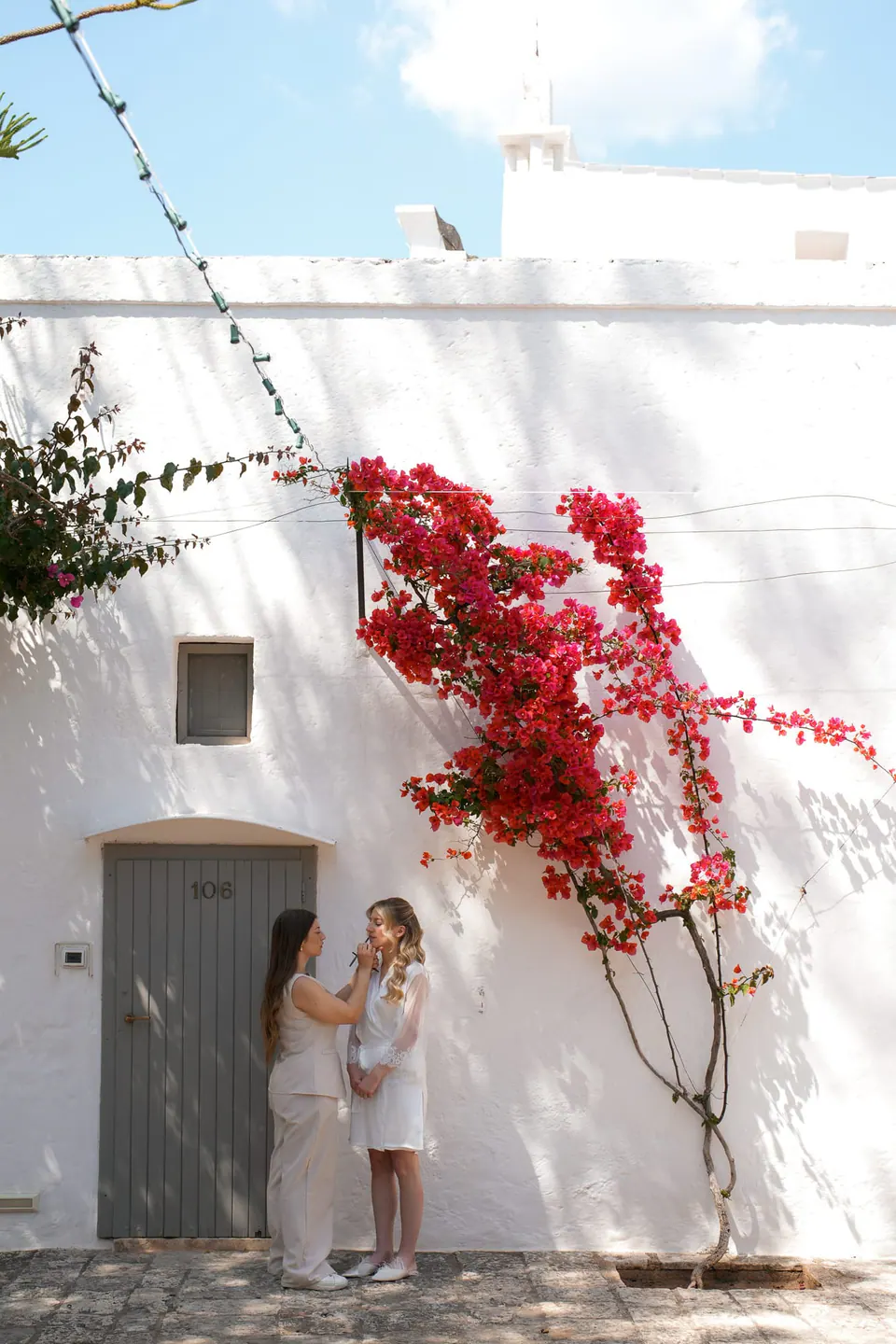 La novia bajo buganvillas rojas en flor, en Apulia.