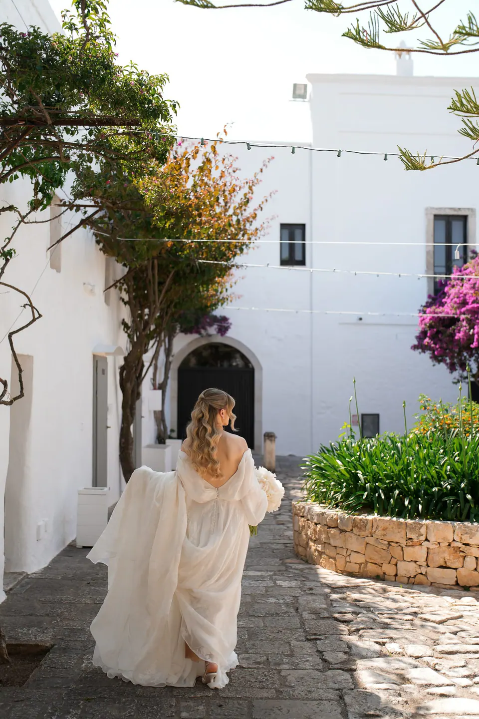 La novia cruza un pueblo encalado de Apulia.