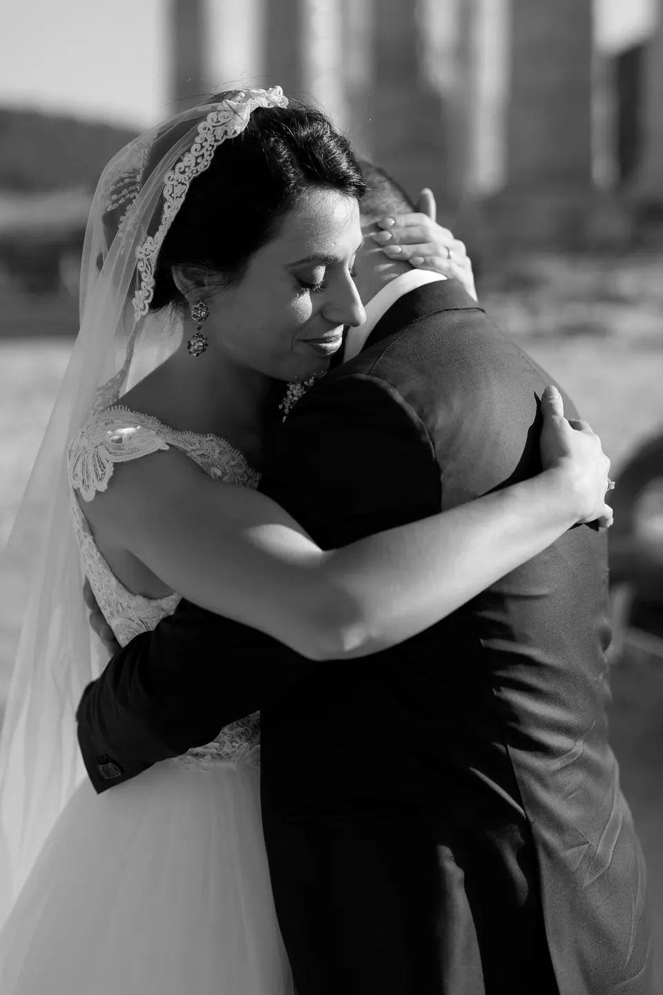 Black and white photo of the bride in a tearful embrace.