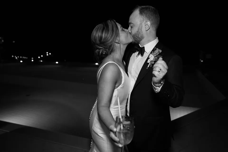 Gli sposi si baciano sotto le luci morbide, momento romantico serale a Ravello.