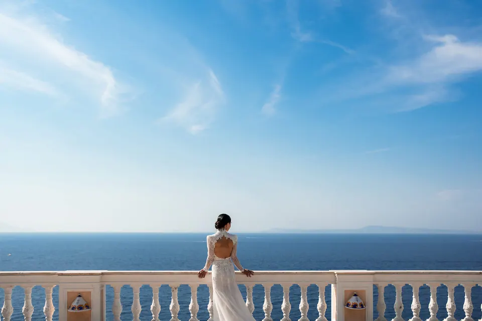 Die Braut allein auf der Terrasse zwischen endlosem Meer und Himmel.