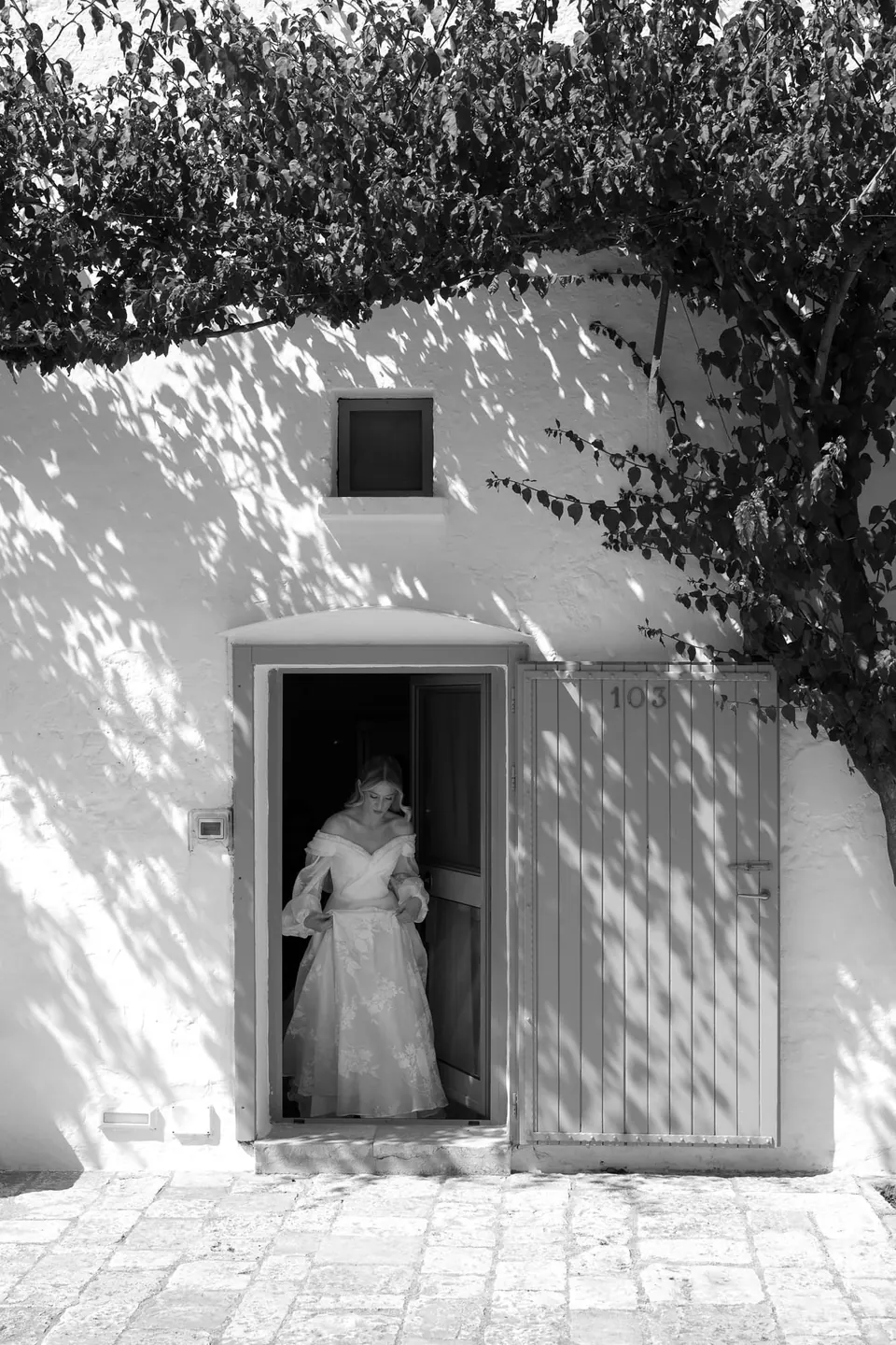La novia enmarcada en una puerta, con luz suave.