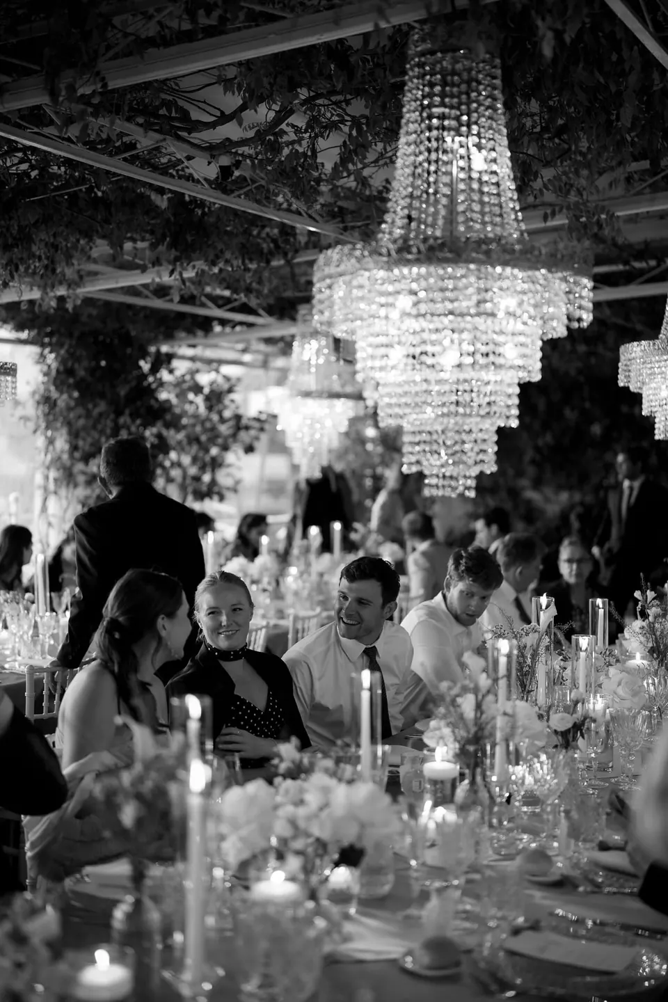 Black and white photo of the dinner under crystal chandeliers.