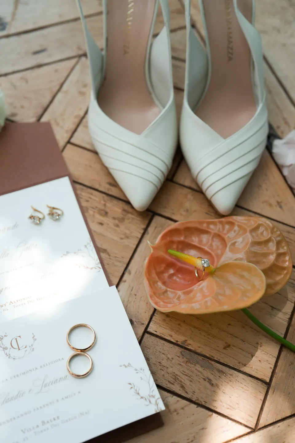Mintgrüne Brautschuhe, Eheringe und eine orange Anthurie auf Holzboden, Detail einer Hochzeit in der Villa Balke.