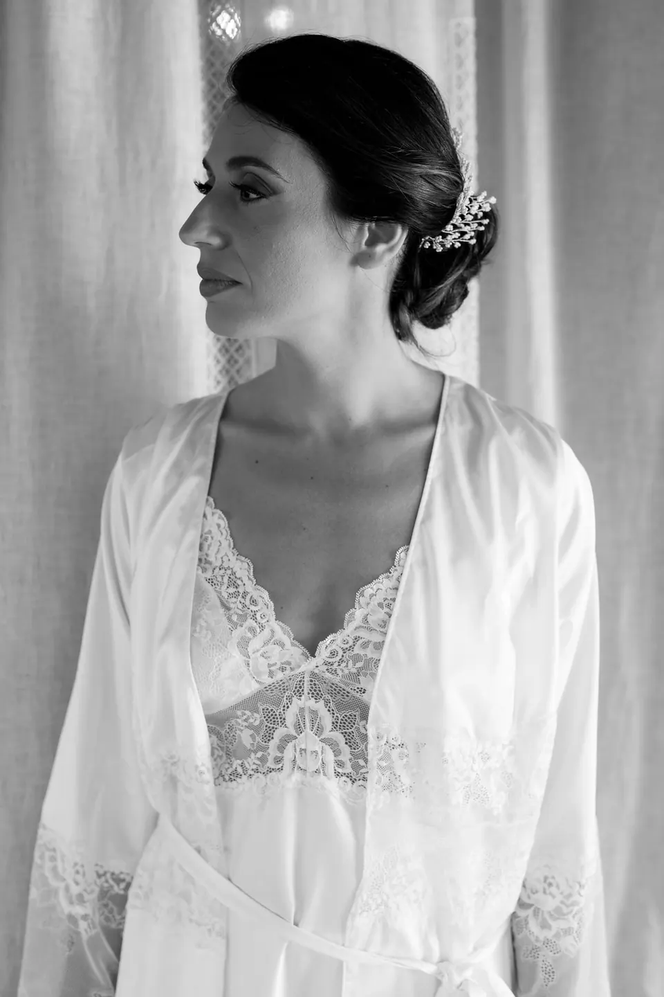 Bride wearing silk robe before the ceremony, editorial bridal preparation portrait.