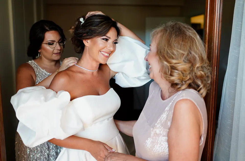 Bride laughing with her mother, joyful pre-ceremony moment.