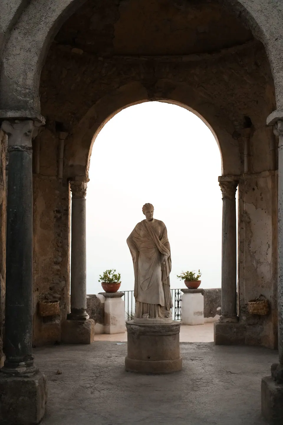 Statue in the Temple of Ceres at Villa Cimbrone, framed by the stone arch.