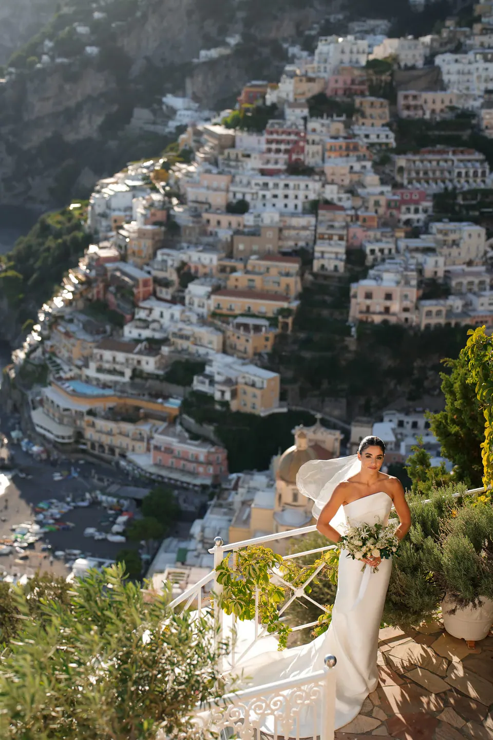 Bride on a terrace high above Positano, the town tumbling down to the sea.