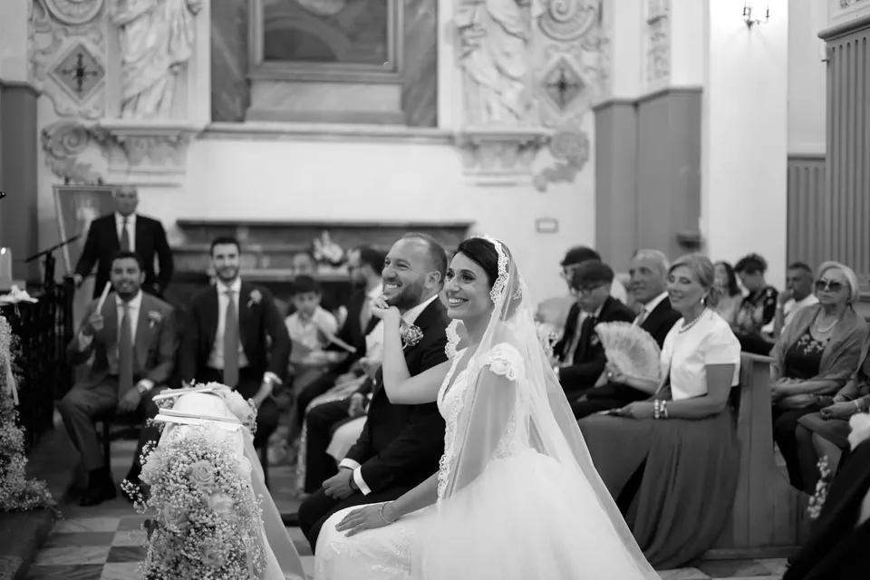 Black and white photo of bride and groom seated during the church ceremony