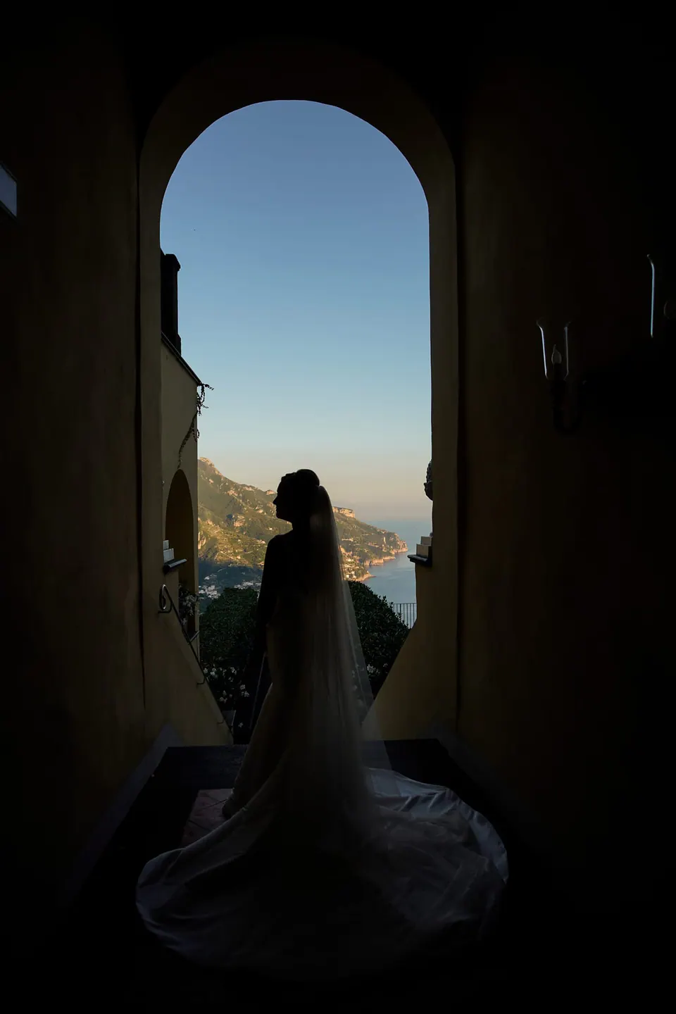 Bride framed by an arched window, delicate editorial portrait at Belmond Hotel Caruso.