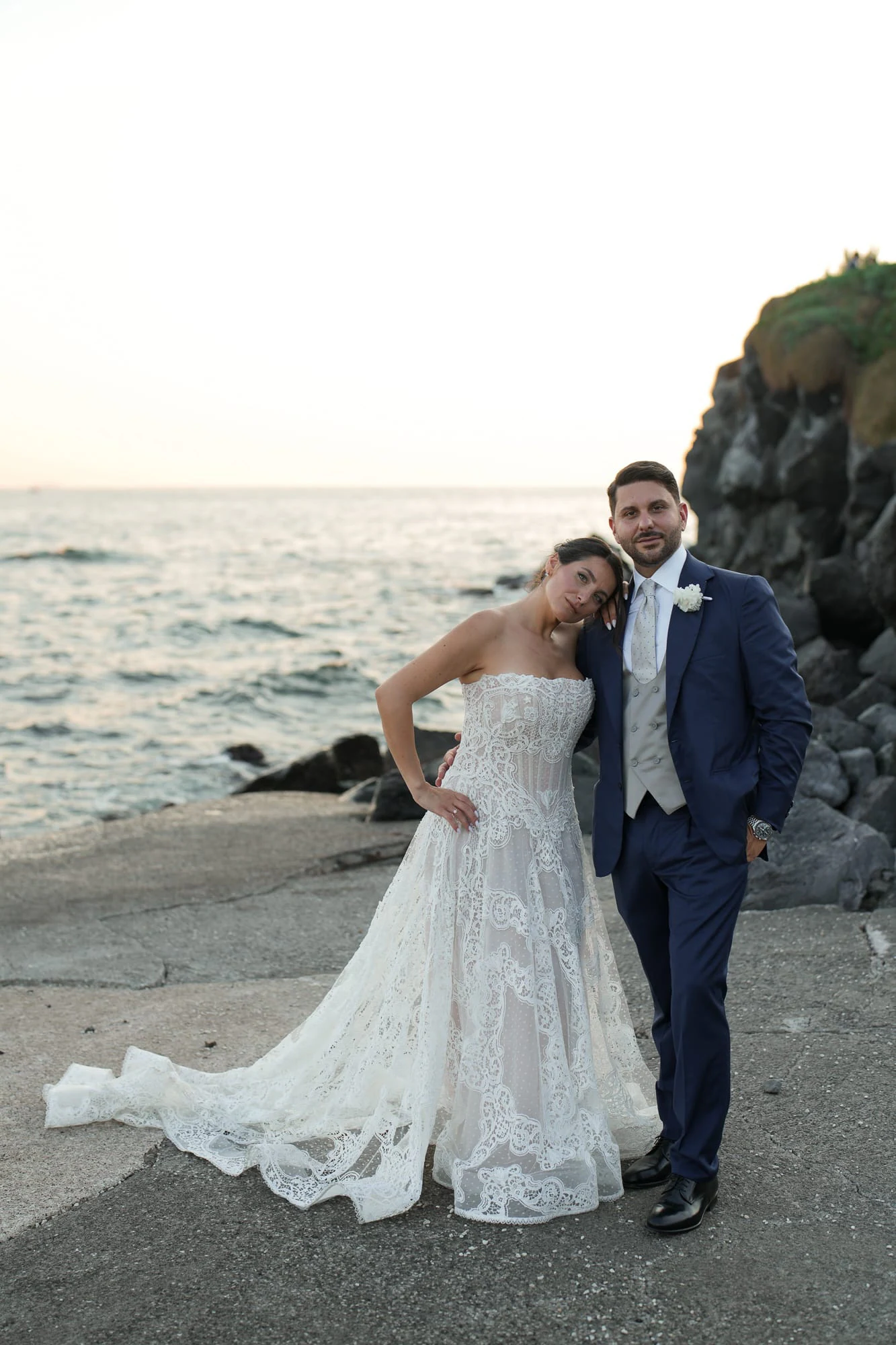 Bride and groom on the rocks by the sea at Villa Balke in Naples.
