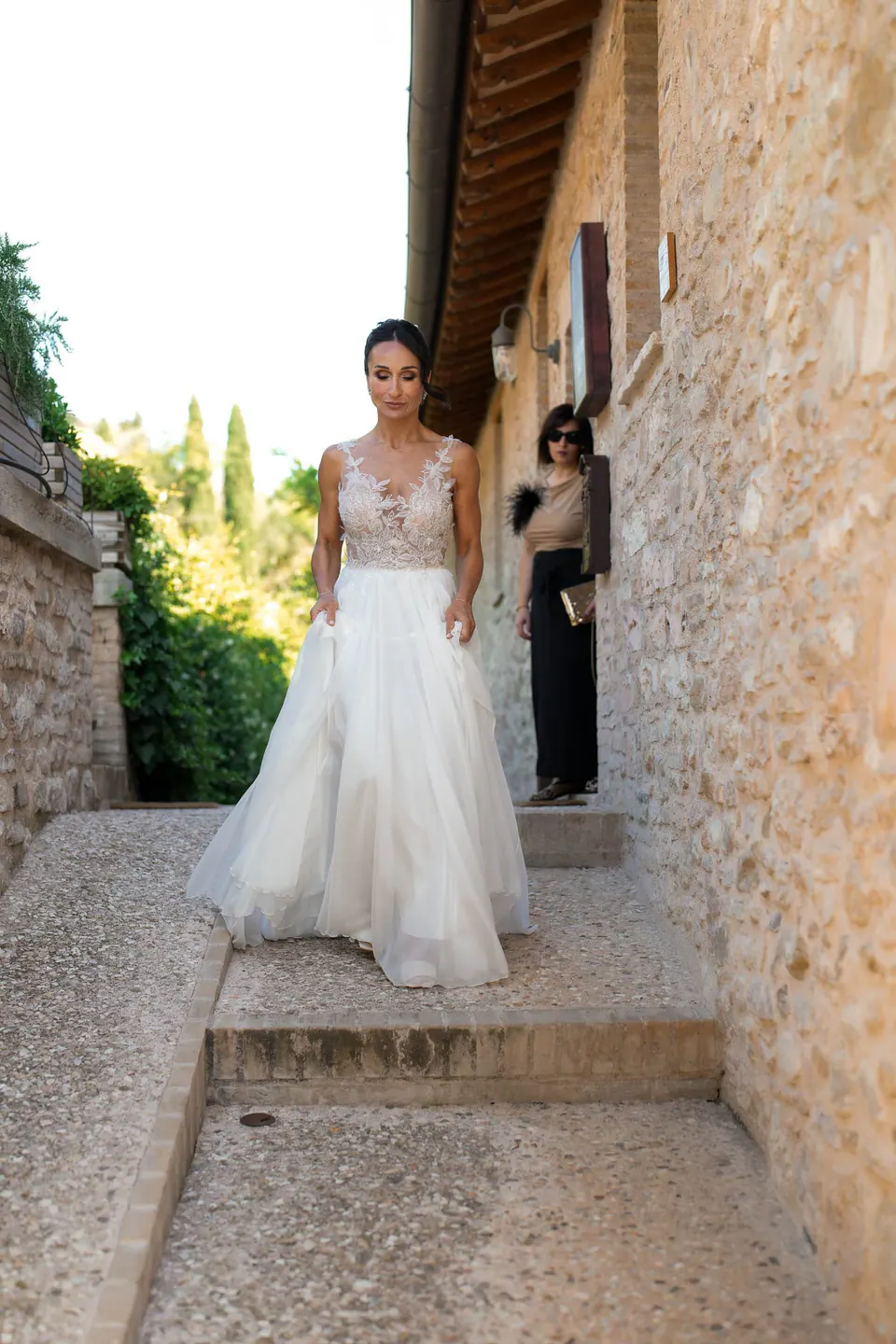 Bride coming down narrow stone steps