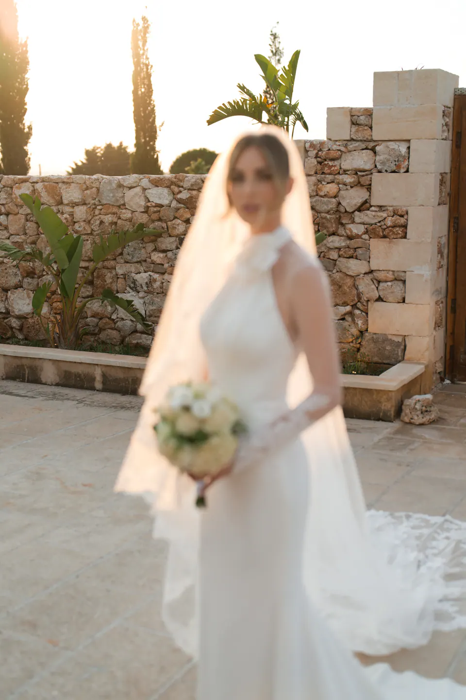 La sposa con il bouquet, il velo che raccoglie la luce calda della sera salentina.