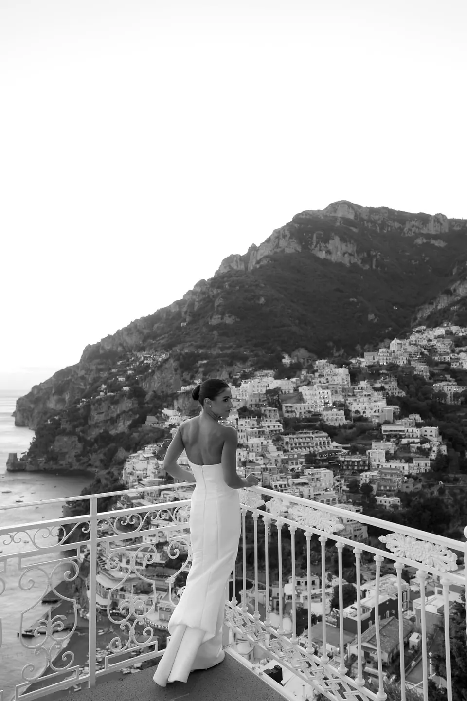 Black and white photo of the bride at the railing looking out at Positano.