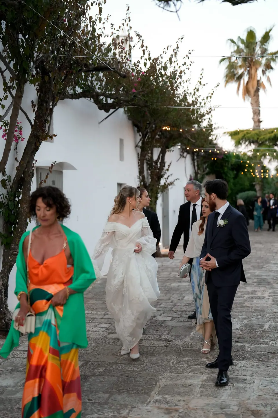 Invitados con ropa de colores celebran bajo el sol mediterráneo.