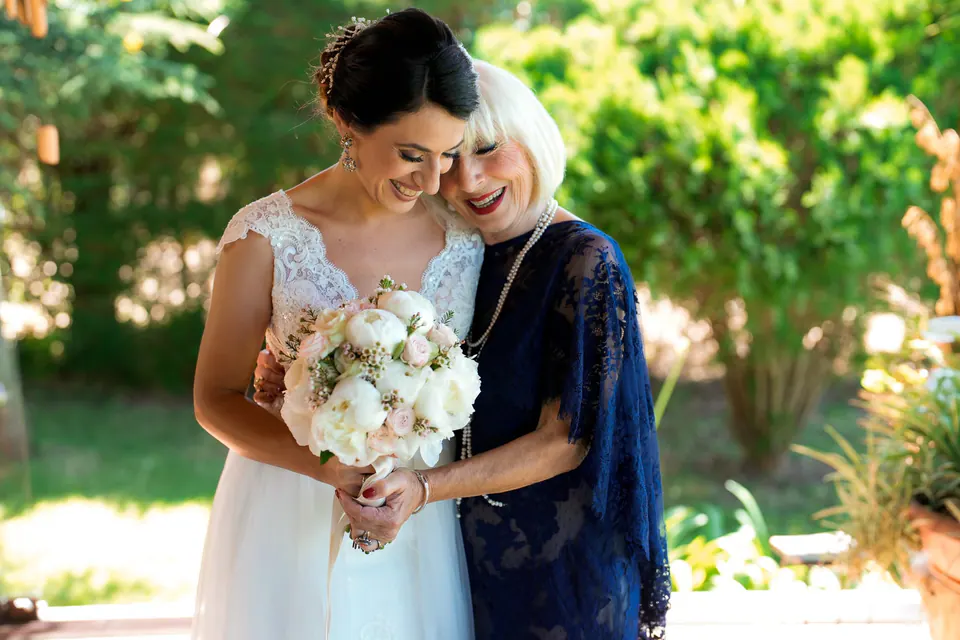 Bride embracing an older woman in the garden