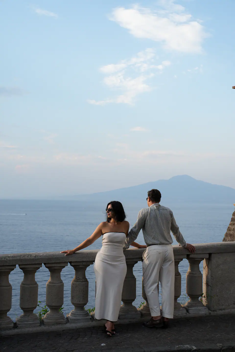 Couple from behind at a balustrade, looking at Vesuvius.
