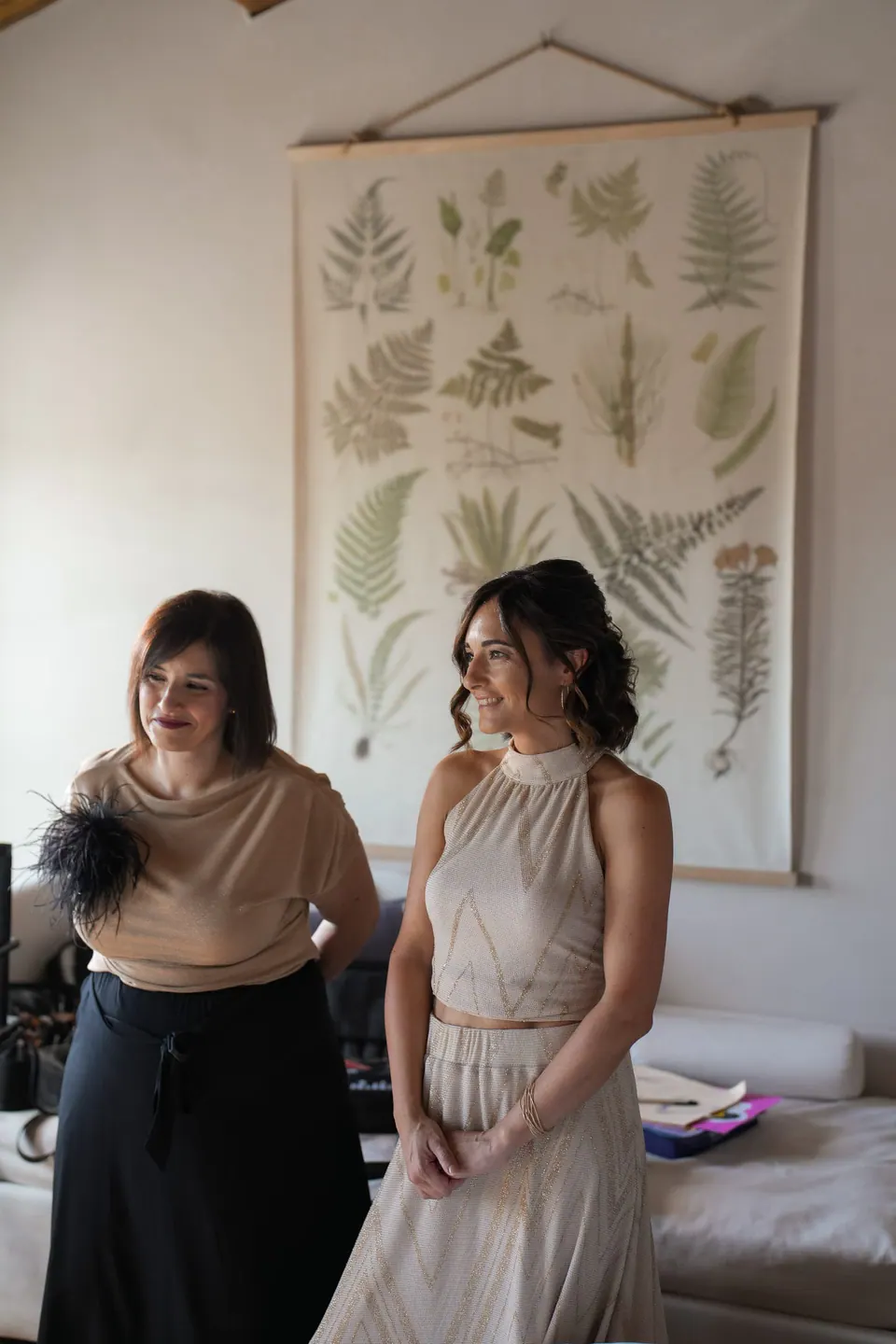 Two women in a room with botanical prints on the wall