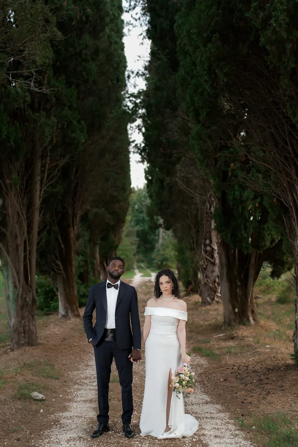 Los novios uno junto al otro en la avenida de cipreses de Villa Ortensia D’Avalos.