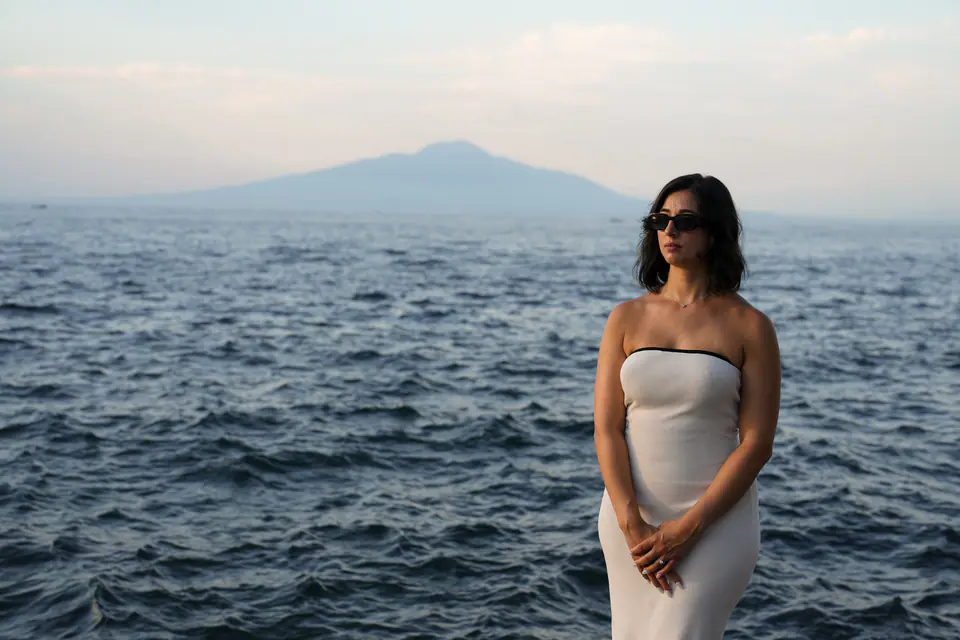 Standing by the sea, Vesuvius in the distance.