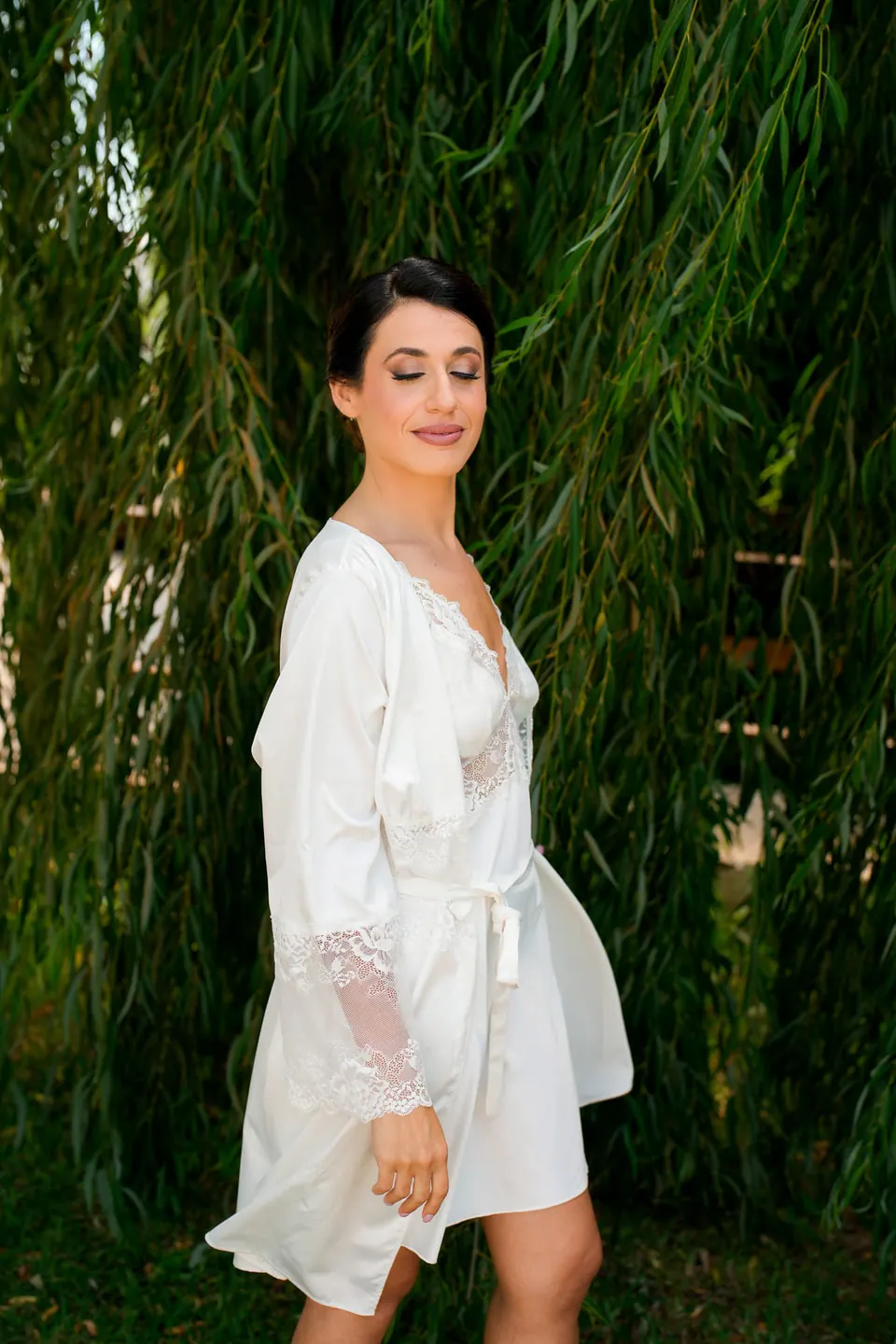 Bride in her robe among the willow branches