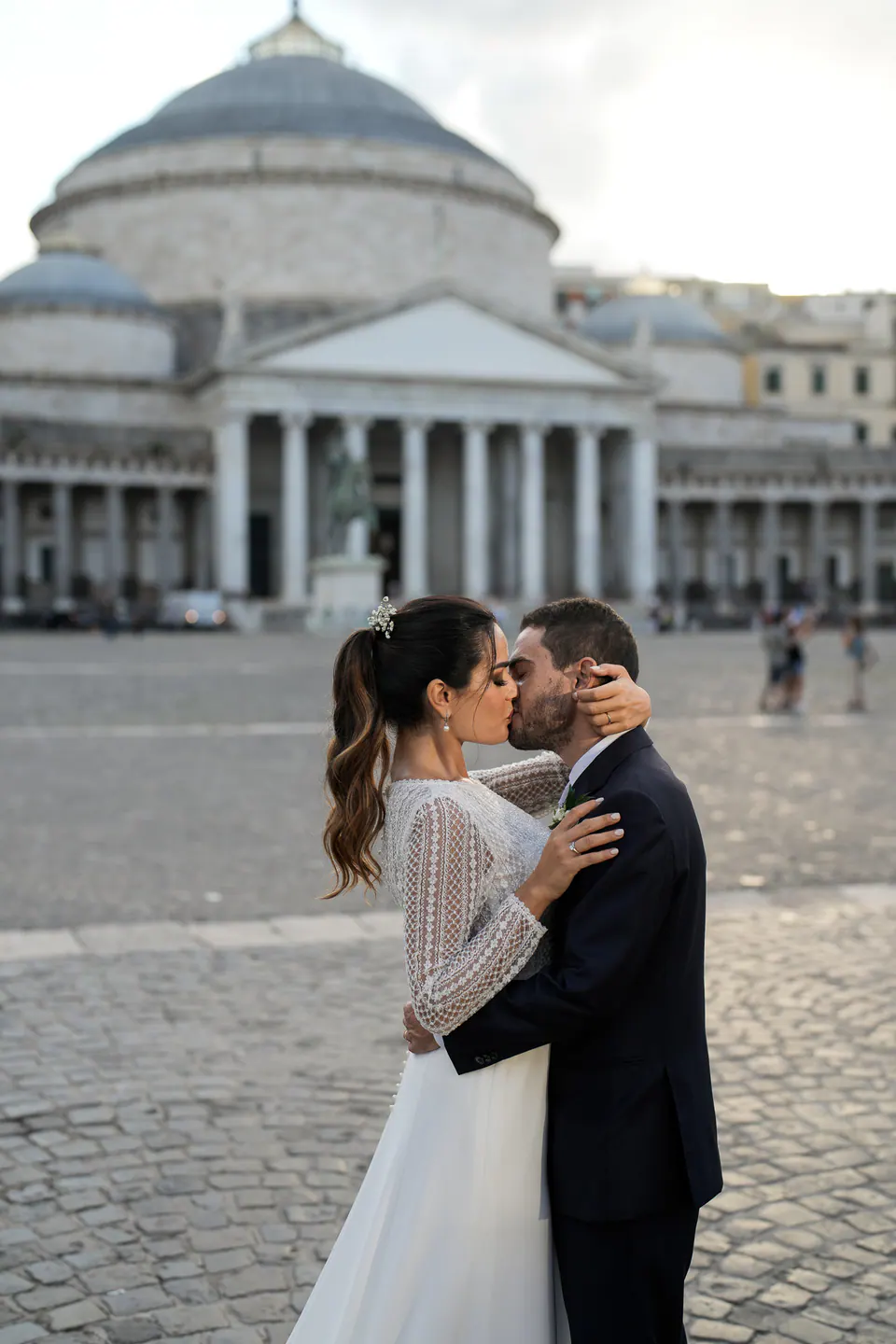 Bride and groom kissing in Piazza del Plebiscito in front of the Basilica of San Francesco di Paola.