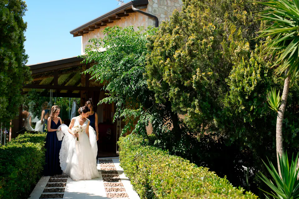 Bride walking through a garden path, romantic Italian countryside wedding.