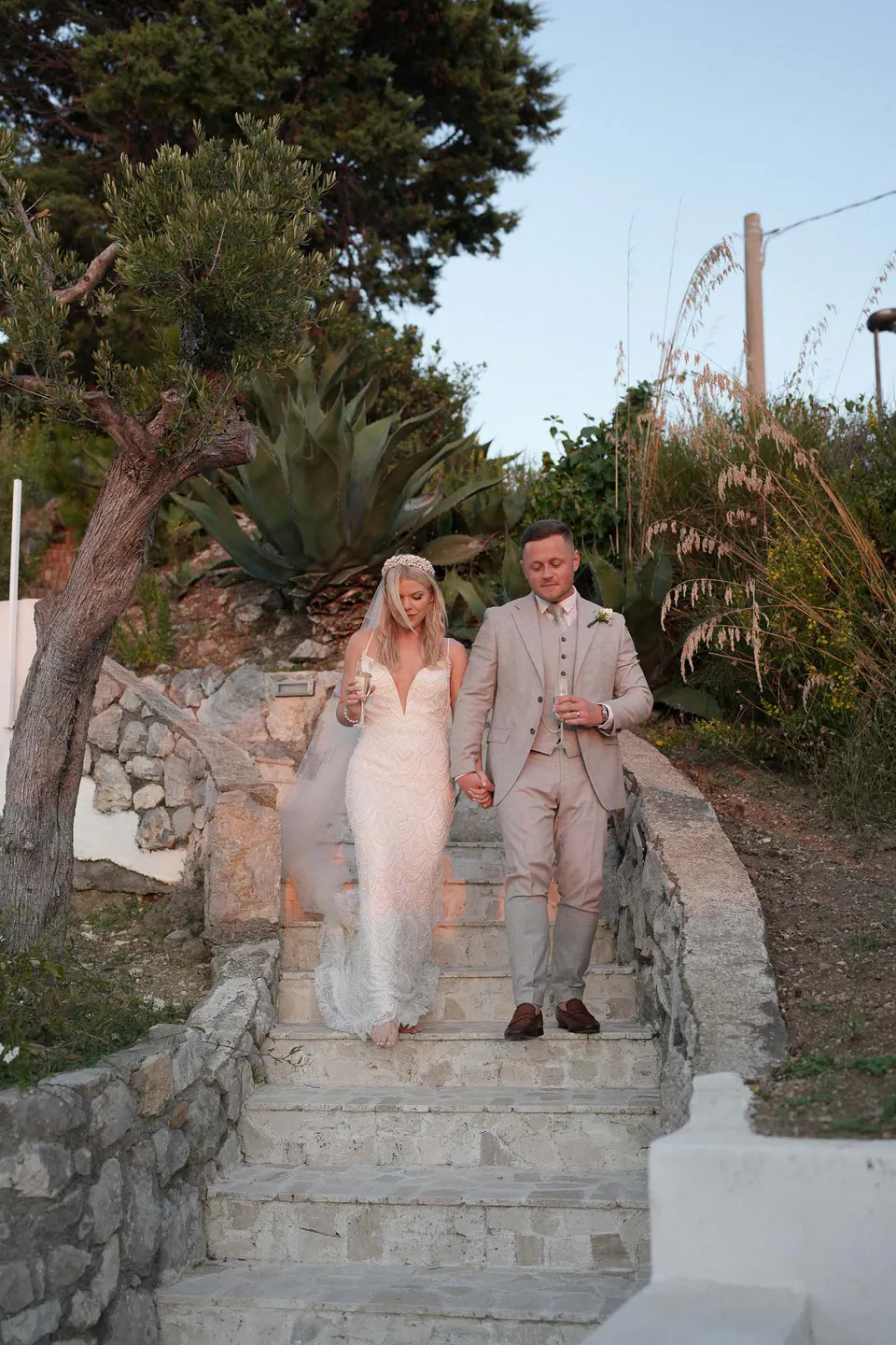 Bride and groom walking down stone steps in the garden