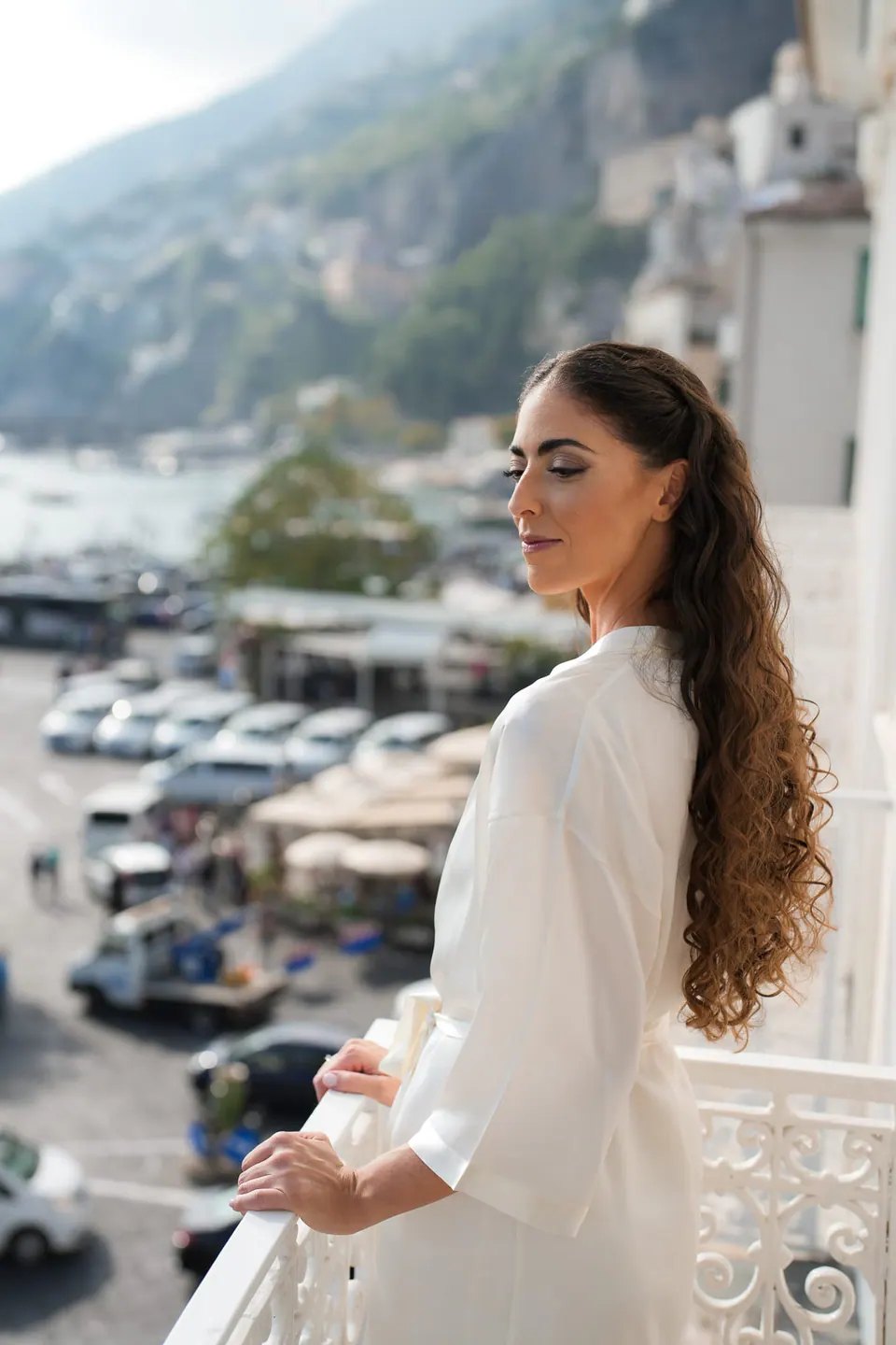 Bride in her robe on the balcony overlooking the harbour of Amalfi.