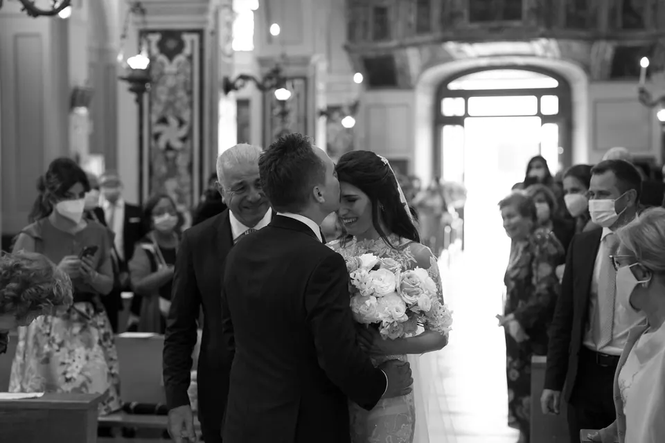 Schwarzweißfoto: Die Braut erreicht mit ihrem Vater den Altar.