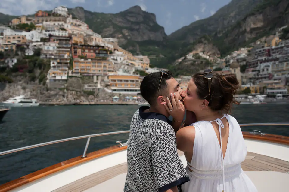 Couple kissing on the boat in front of Positano.