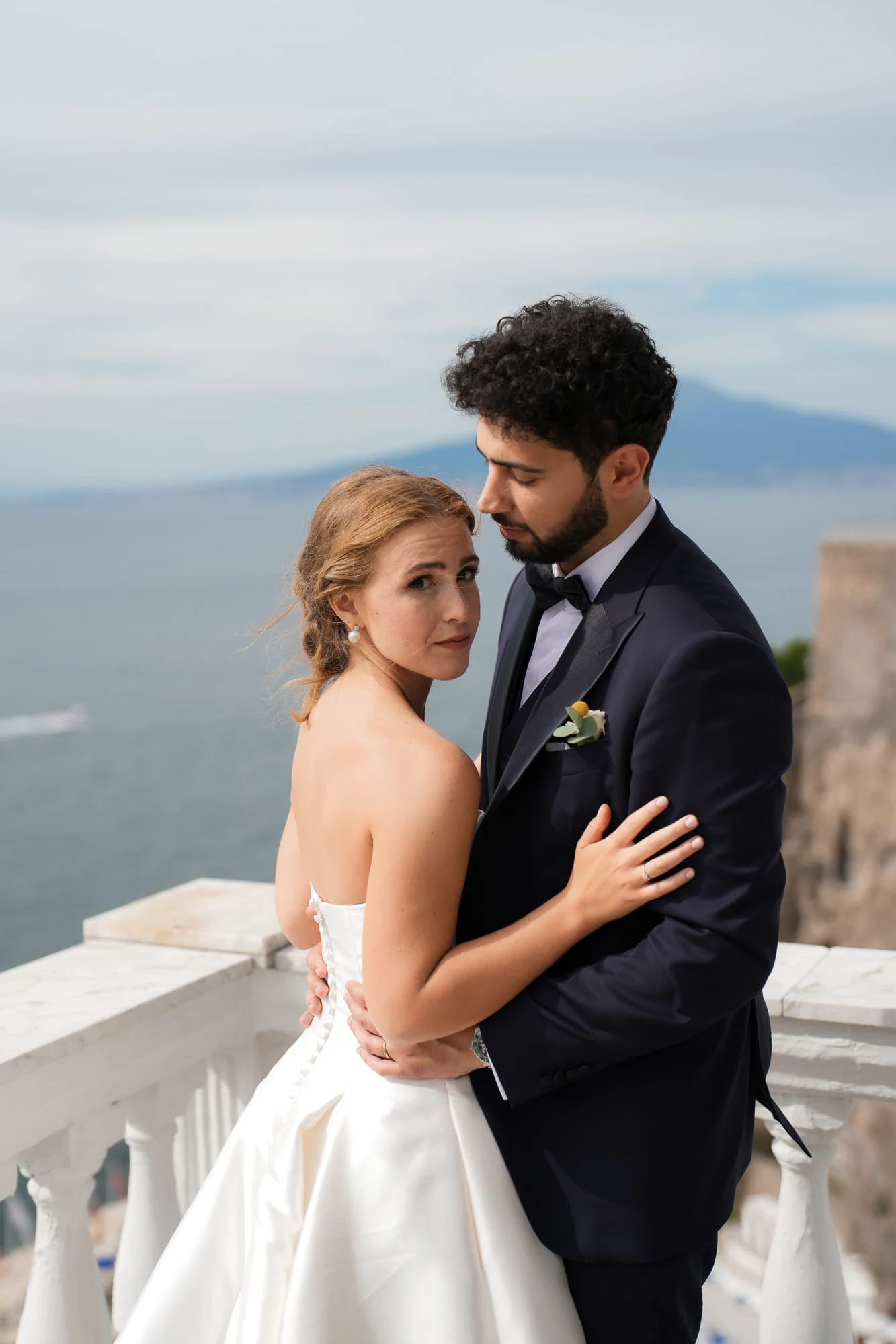 Les mariés enlacés sur la terrasse, le Vésuve de l’autre côté de la baie de Naples.