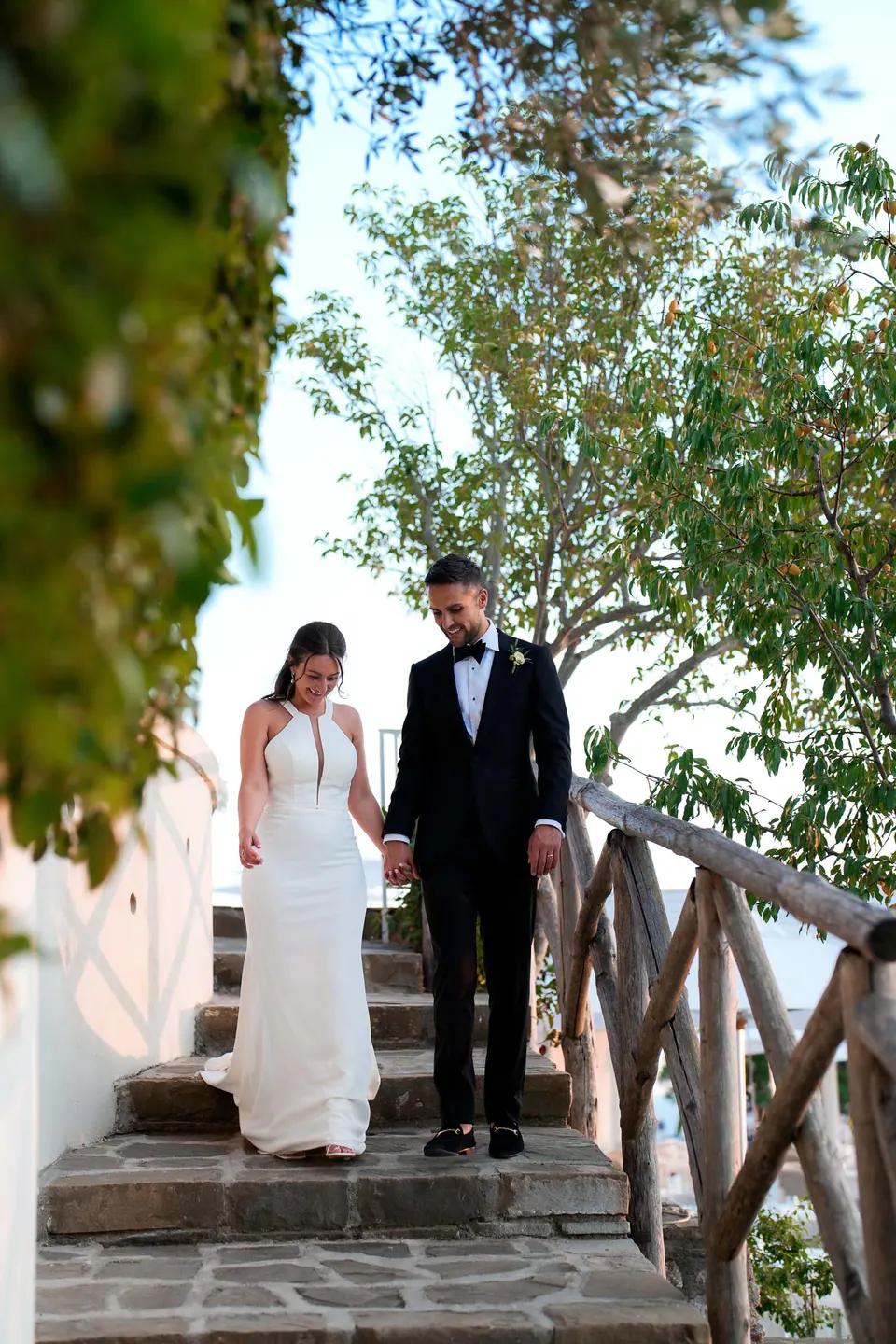 Couple walking through the villa gardens surrounded by lush Mediterranean greenery.
