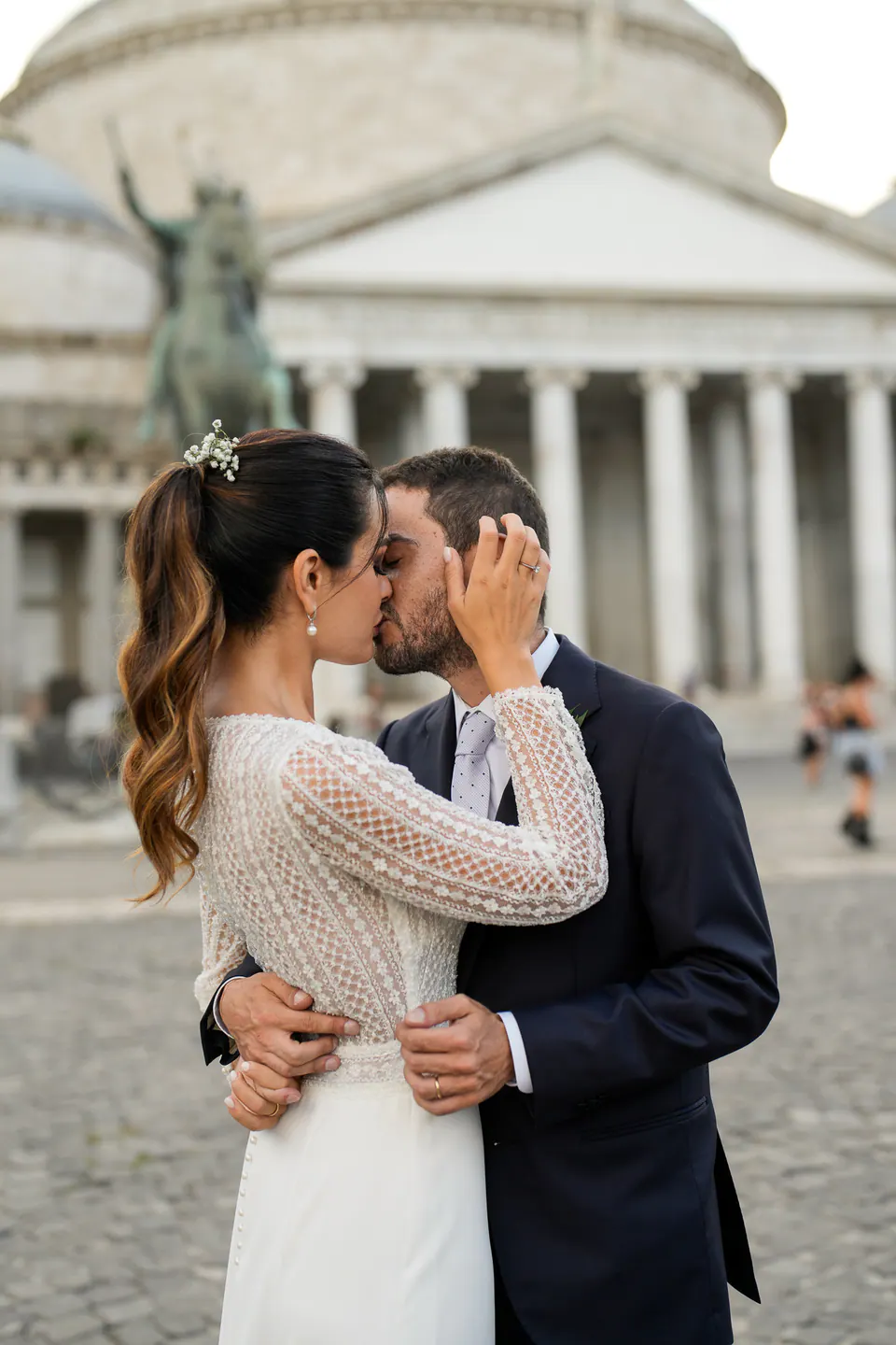 Bride and groom kissing in Piazza del Plebiscito beside the equestrian statue.