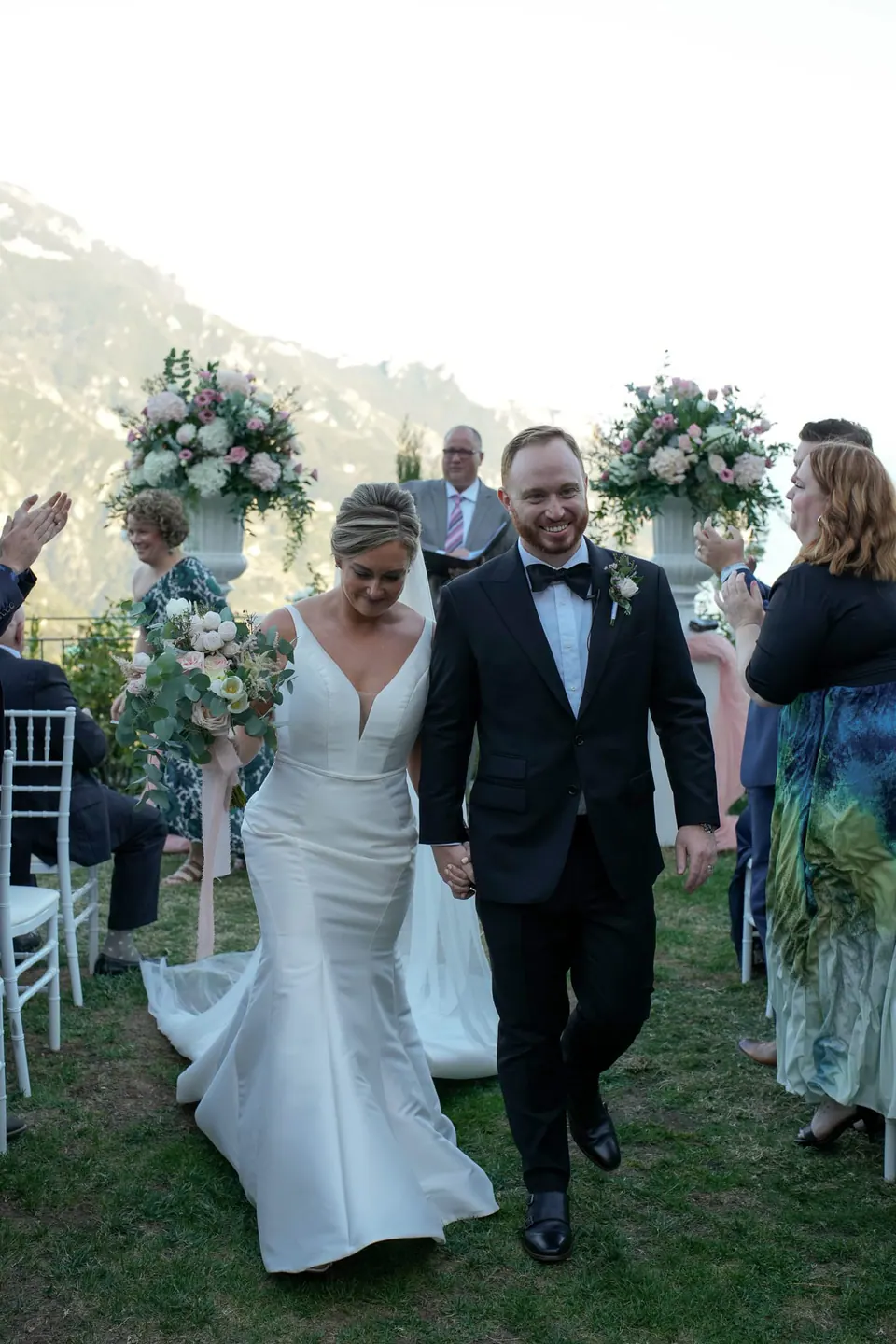 Bride and groom walking back down the aisle after the ceremony in the garden