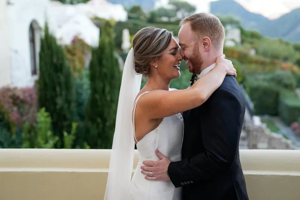 Bride and groom holding each other on a terrace above the gardens of Ravello