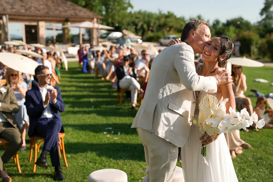 The groom hugging the bride after the ceremony among the guests