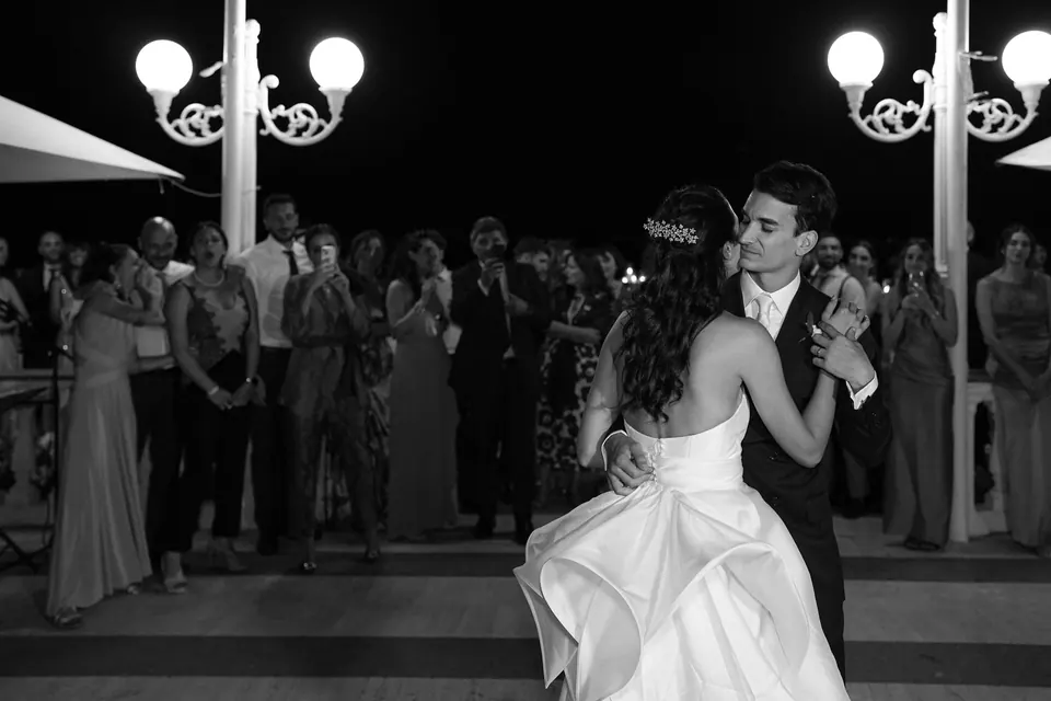 Black and white photo of the first dance on the terrace under the lamps