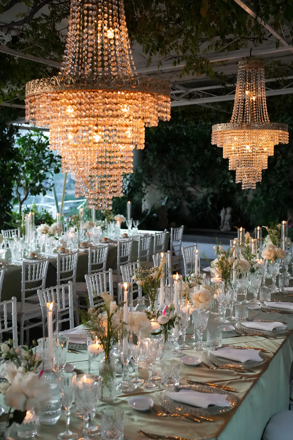 Reception under the pergola, tables set beneath crystal chandeliers.