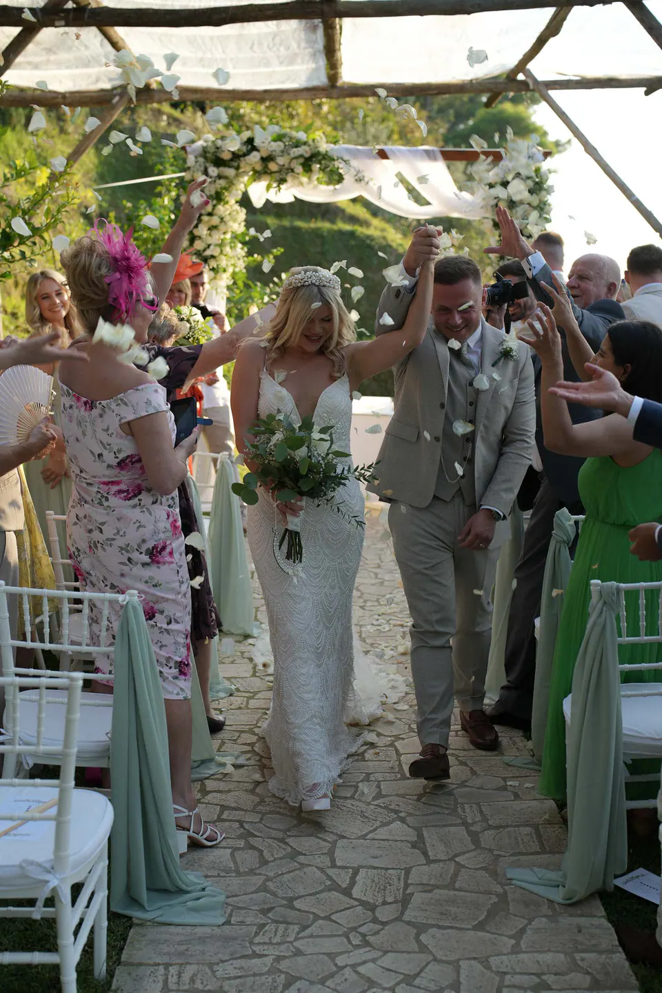 Sposi che ripercorrono la navata tra gli invitati sotto il pergolato