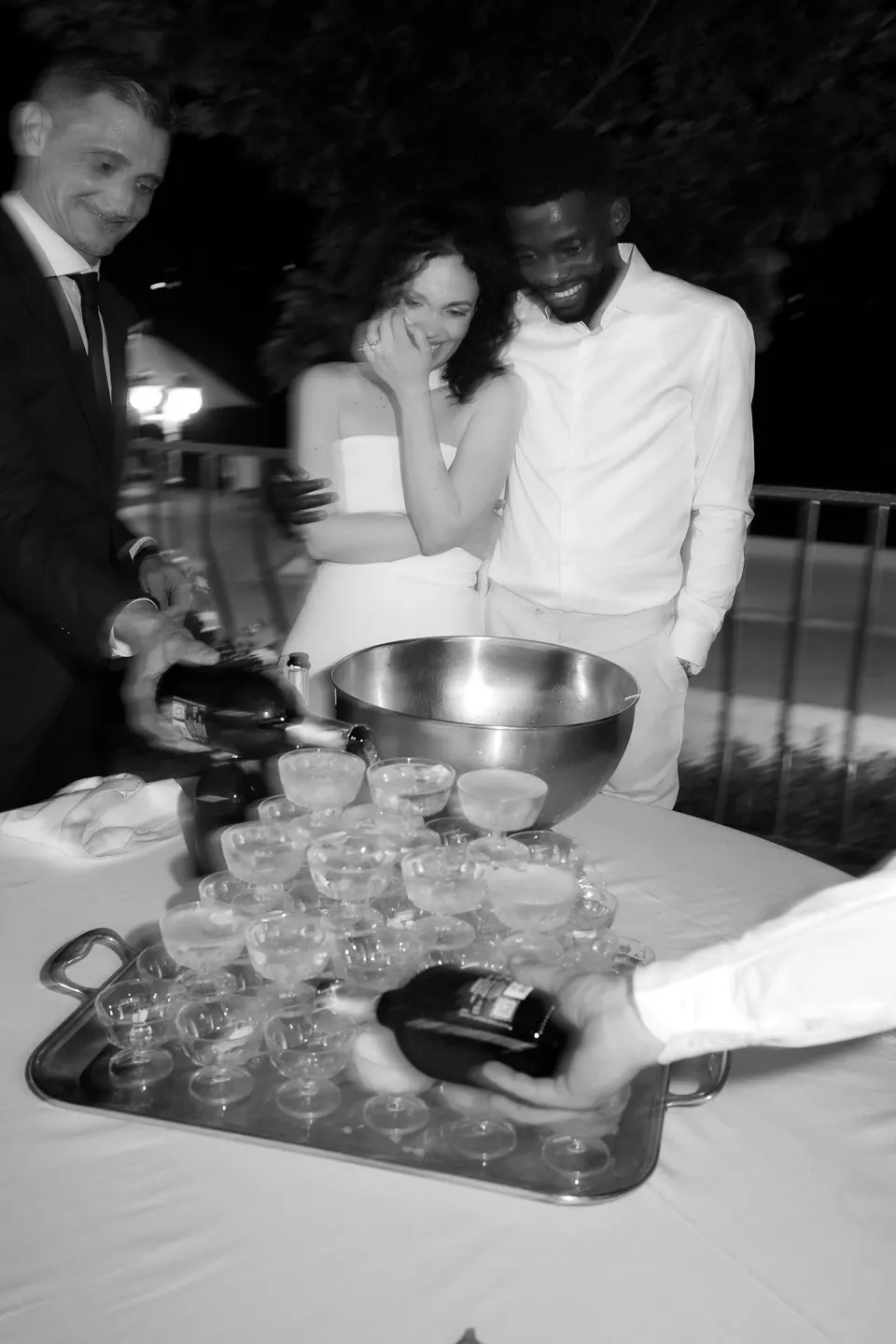Foto en blanco y negro de los novios en la torre de champán durante el banquete de la noche.
