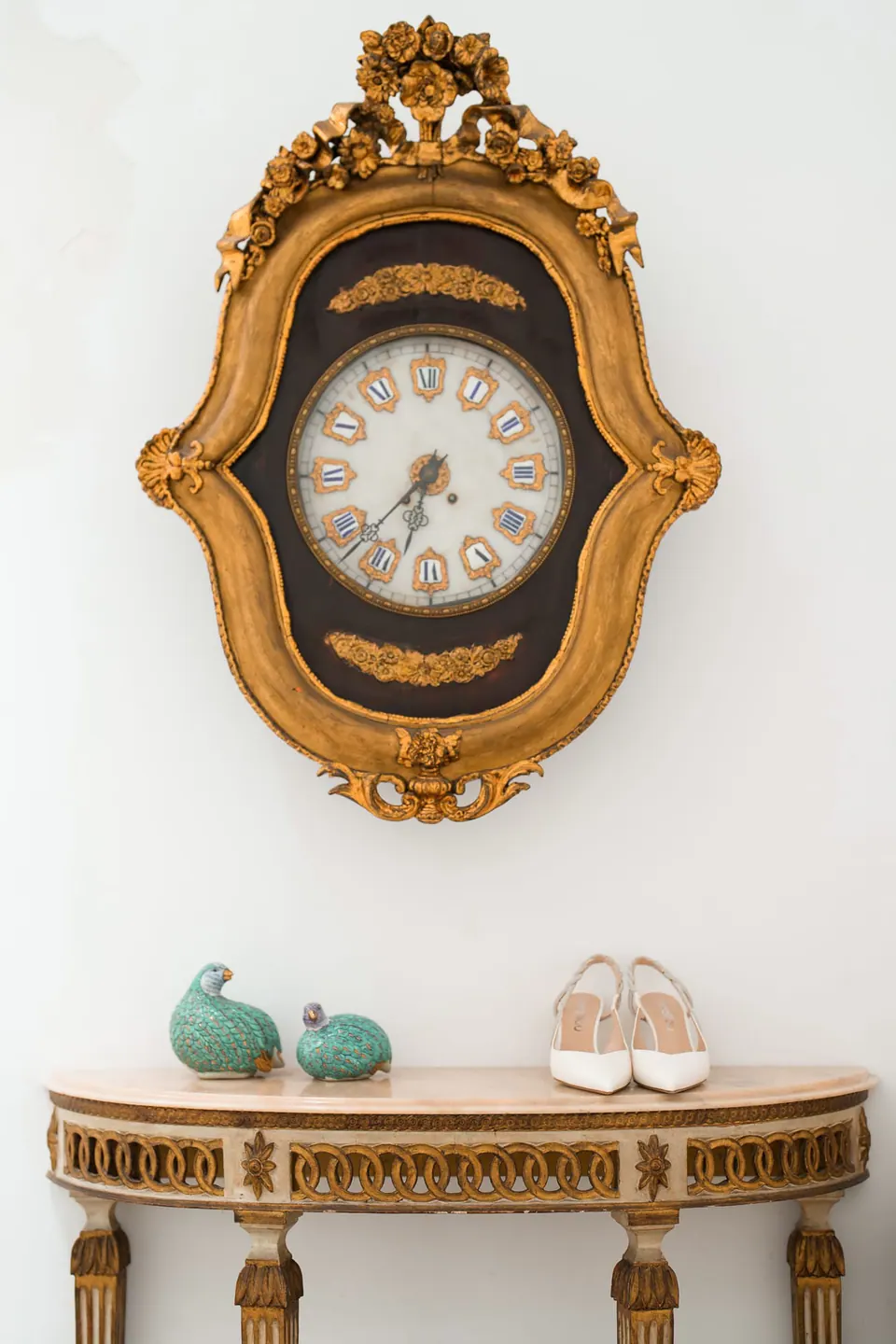 Reloj dorado ornamentado sobre los zapatos de la novia en Tenuta dell’Orso.