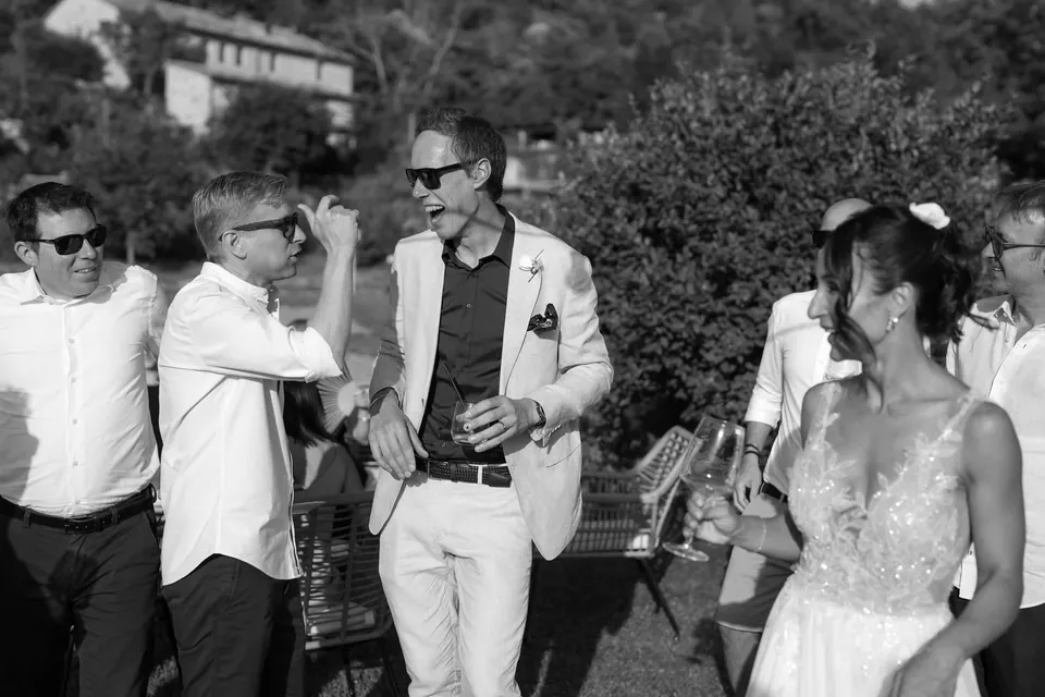 Guests smiling and talking during cocktail hour, natural and spontaneous storytelling moment.